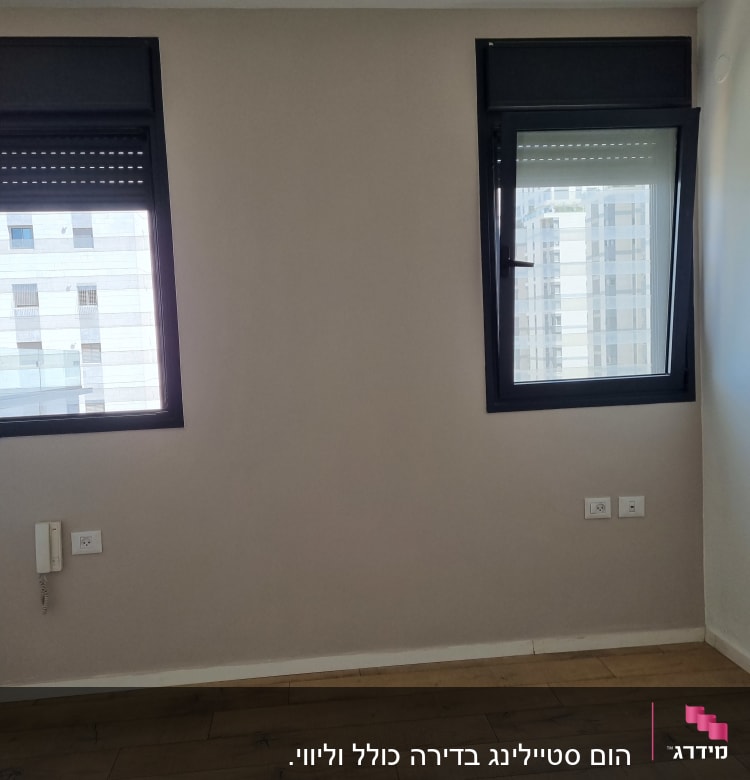 קיר עם שני חלונות, רצפת עץ ושקעי חשמל